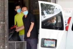 FILE - People remove bags from inside the Chinese Consulate to load into a van in Houston, July 23, 2020.
