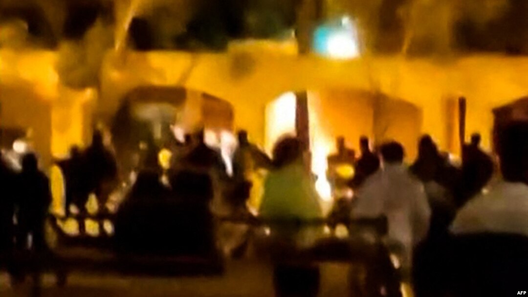 This image grab from a UGC video posted on Nov. 17, 2022, reportedly shows Iranian protesters starting a fire at the family home of the founder of the Islamic republic Ayatollah Ruhollah Khomeini, now a museum, in the central Iranian city of Khomein. (AFP