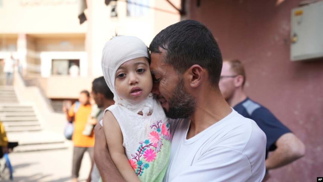 A Palestinian man says goodbye to his sick daughter before she was to leave the Gaza Strip to get treatment abroad through the Kerem Shalom crossing, in Khan Younis, Gaza Strip, June 27, 2024.