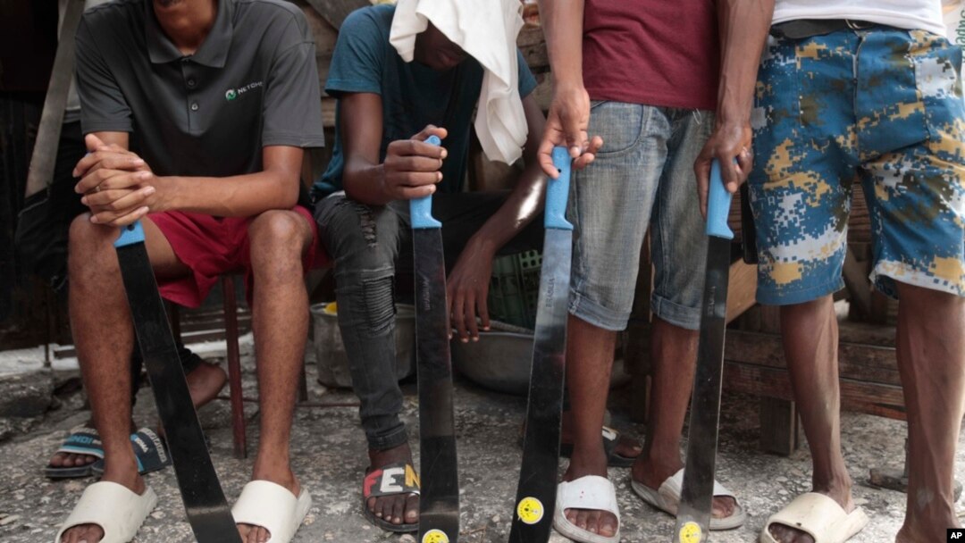 FILE - Community group members hold their machetes in Delmas district as they support the "Bwa Kale" movement, an initiative to fight gangs seeking to take control of their neighborhood in Port-au-Prince, Haiti, May 28, 2023. 