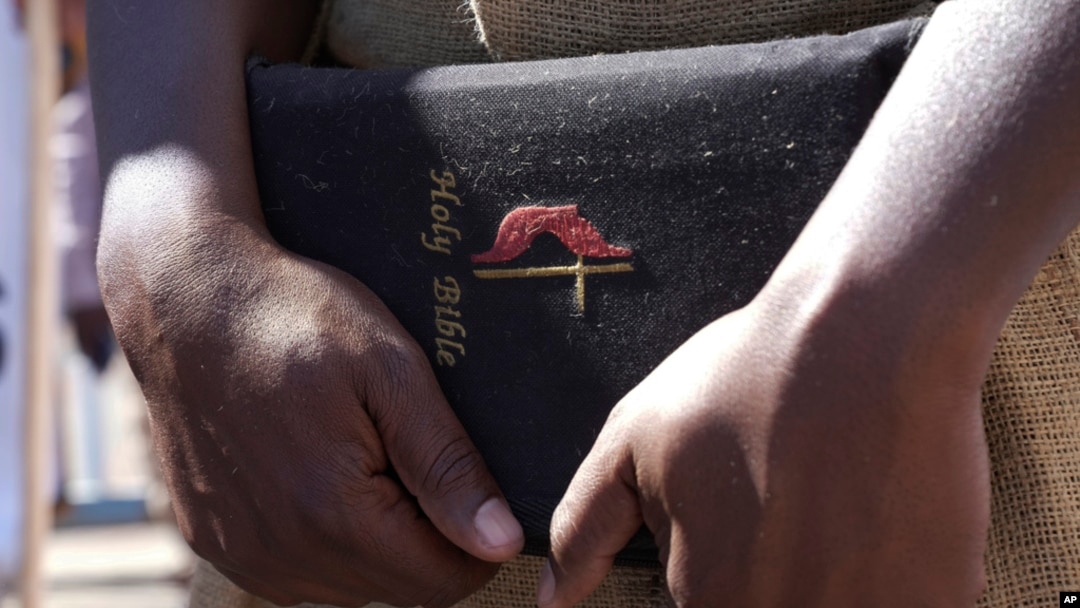 A member of the United Methodist Church in Zimbabwe holds a Bible while protesting at the church premises in Harare, May 30, 2024.
