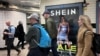 资料照片：英国伦敦市民走过地铁走道旁中国便宜服装品牌Shein的广告牌。（2024年3月8日）