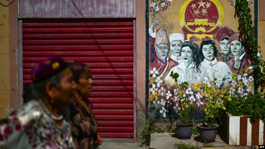 FILE - This picture taken July 14, 2023, shows Uyghur women walking through a neighborhood in Kashgar city in northwestern China's Xinjiang region. 