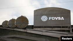 ARCHIVO - Recortes que representan imágenes de operaciones petroleras se ven afuera de un edificio de la petrolera estatal venezolana PDVSA en Caracas, Venezuela, el 28 de enero de 2019.