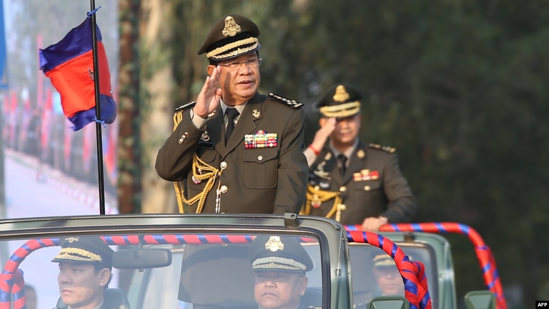 FILE - Cambodian Prime Minister Hun Sen salutes, along with his son Lt. Gen. Hun Manet, during an inspection of troops at a ceremony in Phnom Penh, Cambodia, Jan. 24, 2019. 