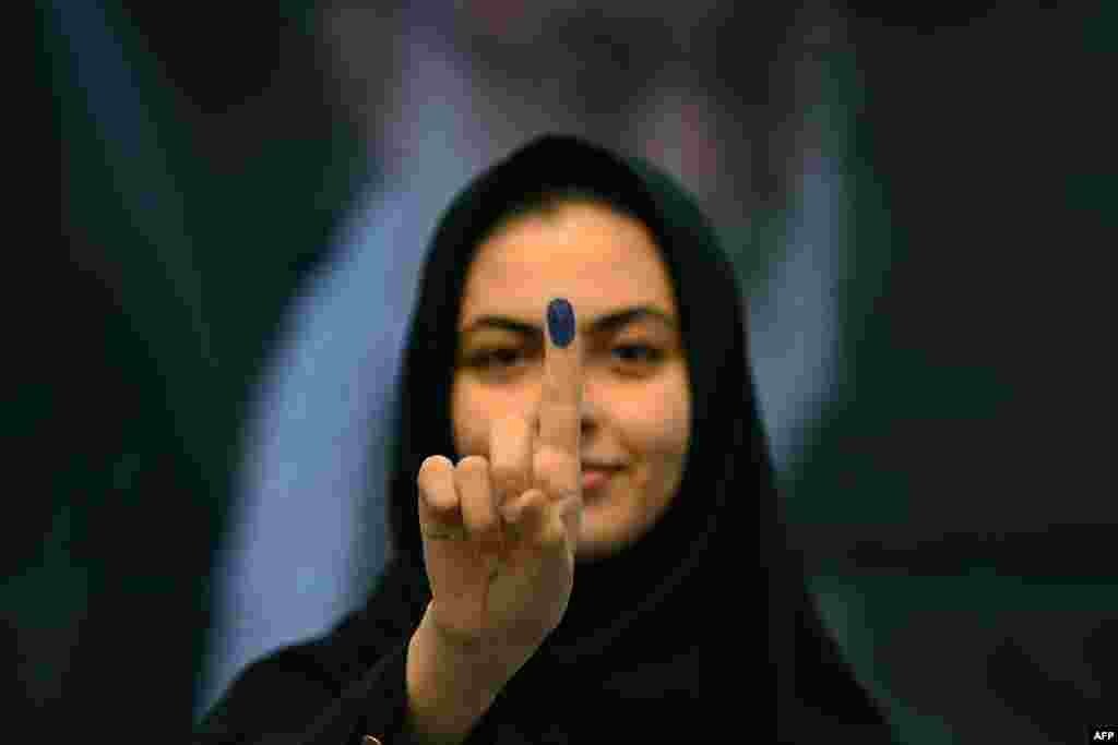 An Iranian national shows her ink-marked finger after voting in the presidential election at the Iranian Embassy in Kuwait City.