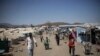 FILE - People walk along the main road of Kumer refugee camp, near Maganan, 70 km from the Sudanese border in Ethiopia's Amhara region, on Feb. 29, 2024. 