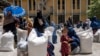 FILE - Afghan women receive food rations distributed by a humanitarian aid group, in Kabul, Afghanistan, May 28, 2023. A U.N. survey found 80% of women in Afghanistan reported a drop in their ability to undertake income-generating activities under the Taliban.