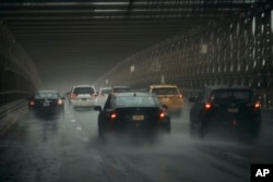 Cars move along Brooklyn Bridge under heavy rain on Sept. 29, 2023, in New York.