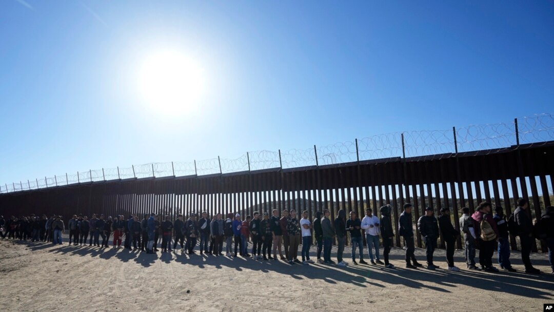 FILE - People line up to receive food from volunteers with Border Kindness after crossing the border with Mexico, near Jacumba, California, Oct. 24, 2023.