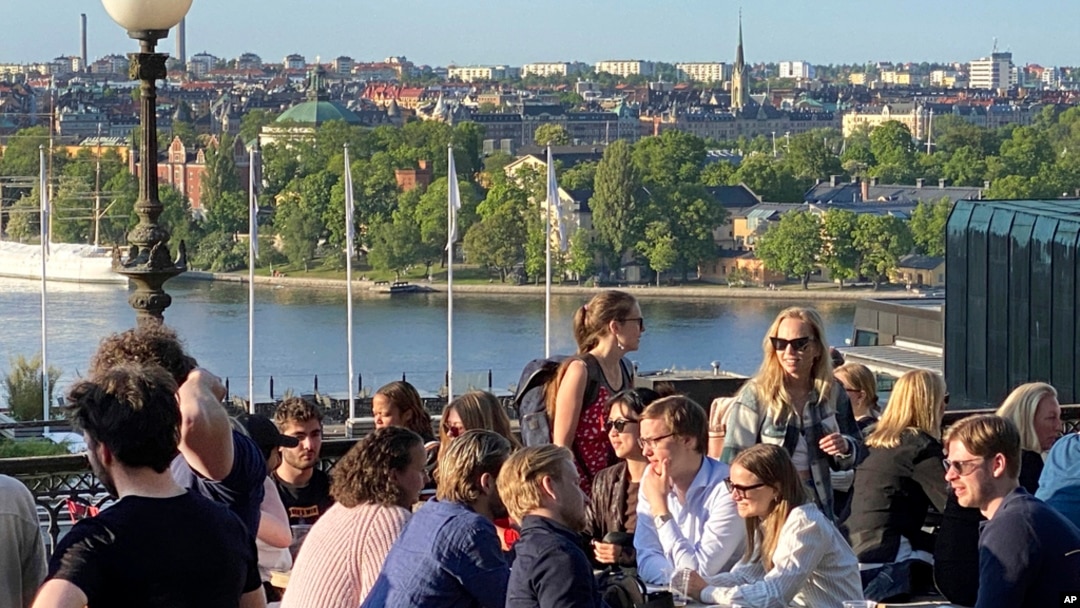 People enjoy drinks and snacks in the evening sun on a terrace overlooking Stockholm, on May 30, 2023.