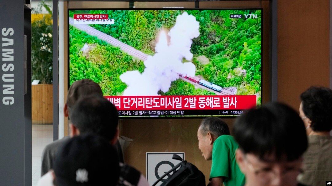 19일 한국 서울역 이용객들이 북한 단거리 탄도미사일(SRBM) 2발 발사 TV뉴스를 시청하고 있다.