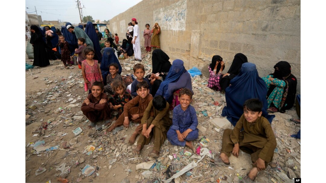 FILE - Afghan families wait to board a bus to depart for their homeland, in Karachi, Pakistan, Oct. 6, 2023. Pakistan's government announced a major crackdown on illegal migrants in the country. (AP Photo/Fareed Khan)