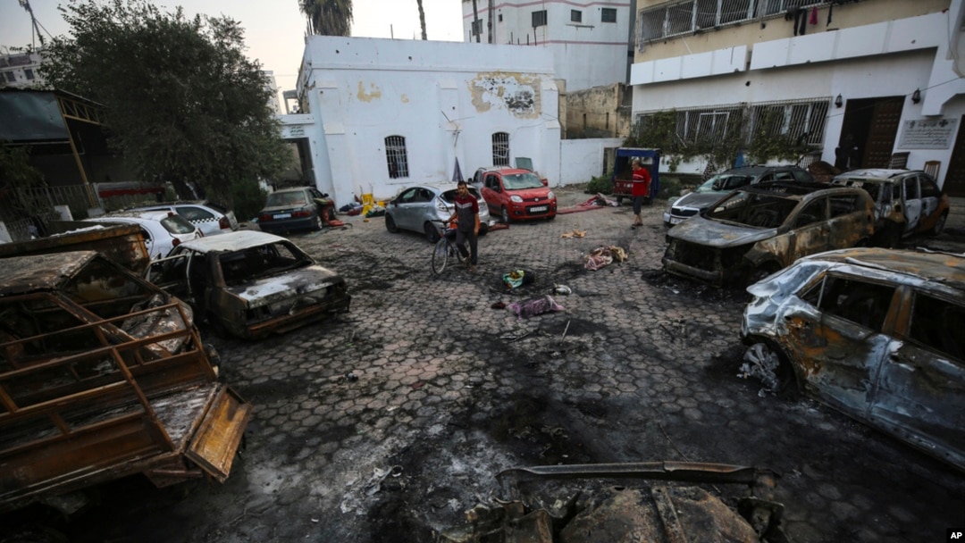 Palestinians check the site of the explosion at Ahli Arab Hospital, in Gaza City, Oct. 18, 2023.