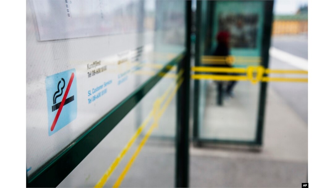 FILE - A no smoking sign is seen at a bus stop in Stockholm, Sweden, June 25, 2019.