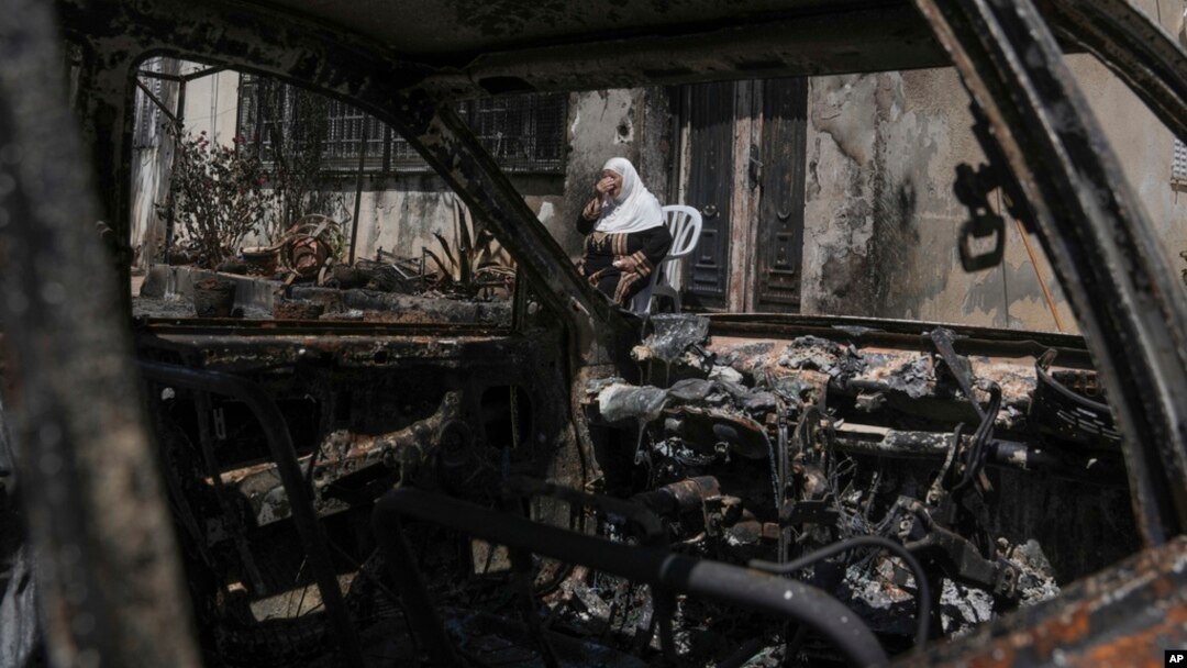 A Palestinian woman sits outside her torched home, days after it was set on fire by Jewish settlers, in the West Bank town of Turmus Ayya, June 24, 2023. 