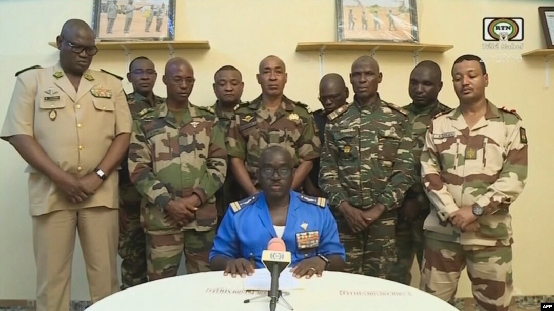This video frame grab image obtained by AFP from ORTN - Télé Sahel on July 26, 2023, shows Colonel Major Amadou Abdramane, center, spokesperson for the National Committee for the Salvation of the People, speaking during a televised statement in Niger.