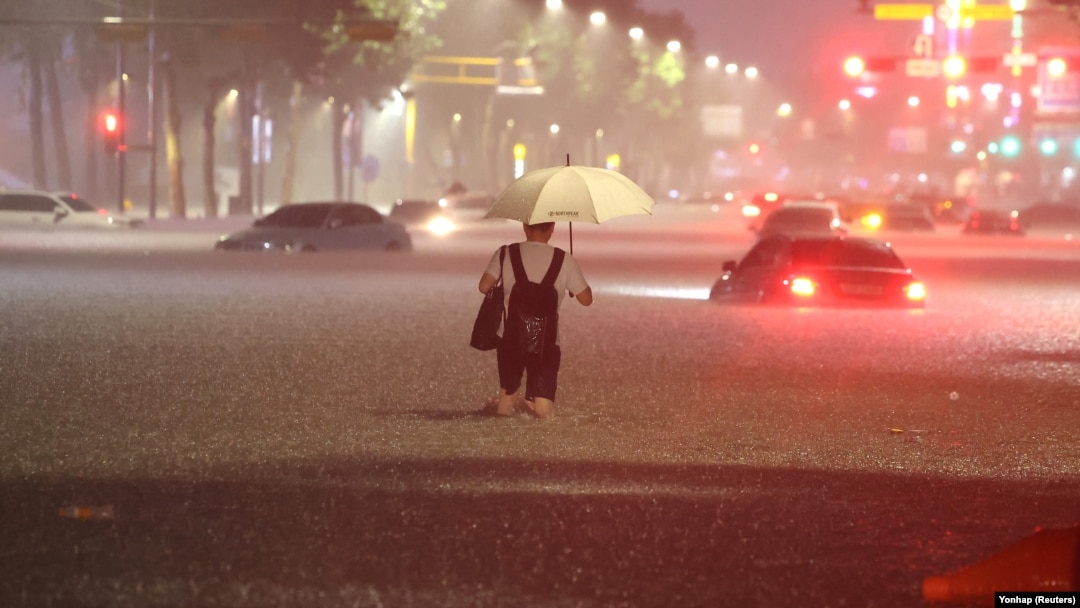 A man makes his way through flooded area during heavy rain in Seoul, South Korea, on August 8, 2022.