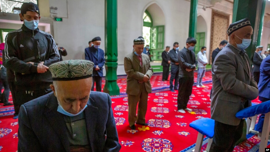 FILE - Uyghurs pray at the Id Kah Mosque in Kashgar in far west China's Xinjiang region, as seen during a government-organized visit for foreign journalists, April 19, 2021.