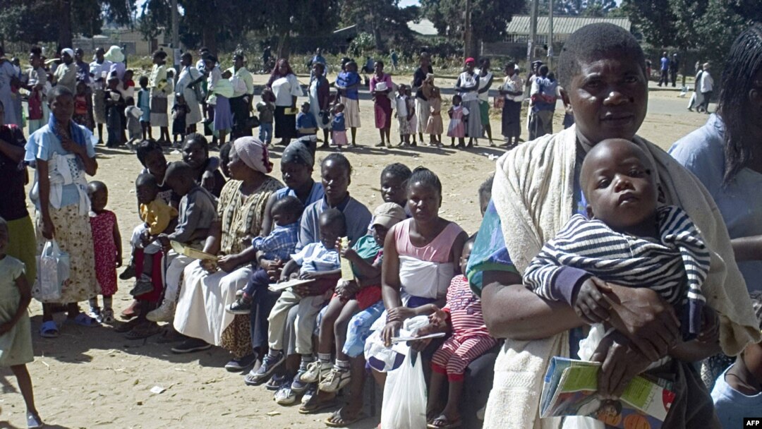 FILE - Women line up to have their children immunized against measles in Mabvuku, Zimbabwe, a suburb of the capital city of Harare. An August 2022 measles outbreak in Zimbabwe has killed at least 157 children. 