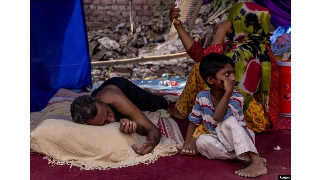 FILE - A Rohingya refugee family rests in a temporary shelter after a fire destroyed a Rohingya refugee camp on Saturday night, in New Delhi, India, June 14, 2021. (REUTERS/Danish Siddiqui)
