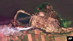 This composite of satellite images taken by Planet Labs PBC shows smoke rising from fires at the Zaporizhzhia nuclear power plant in southeastern Ukraine, Aug. 24, 2022. A team from the U.N.'s International Atomic Energy Agency is expected to visit the Ru