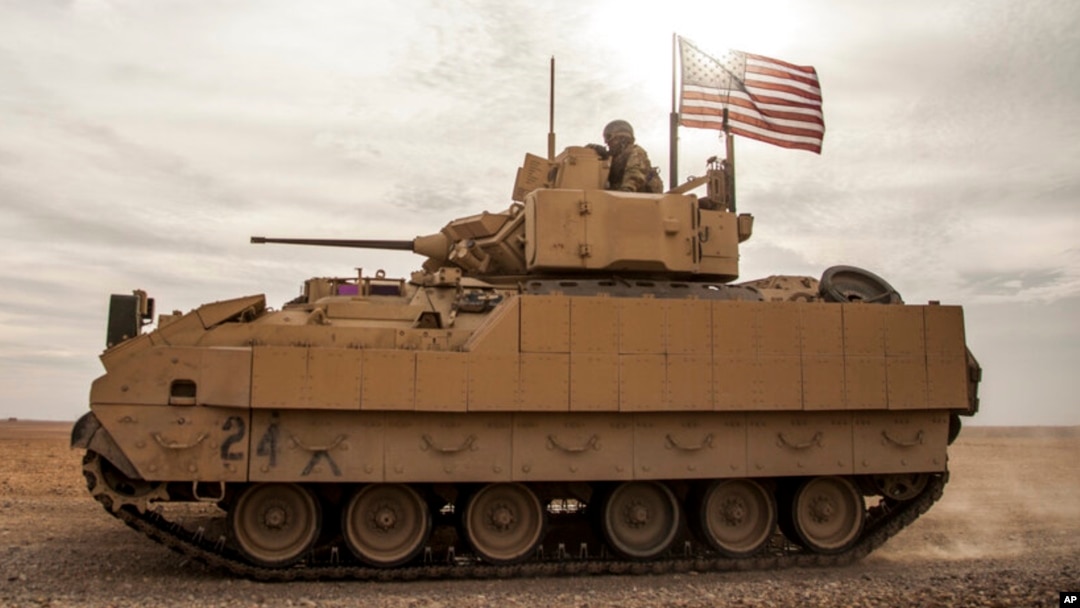 FILE - American soldiers drive a Bradley Fighting Vehicle during a joint exercise with Syrian Democratic Forces in northeastern Syria, Dec. 8, 2021. The U.S. will be sending Bradleys to aid Ukraine in its battle against Russian invaders.