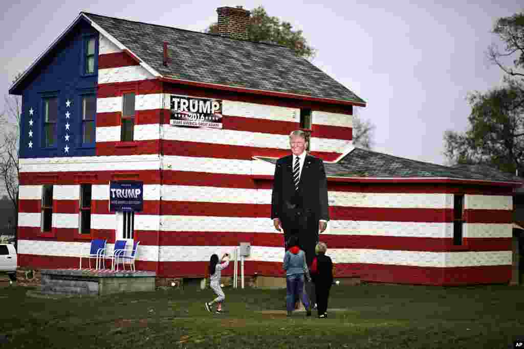 A young visitor takes a photo of a giant cutout of Republican candidate for president Donald Trump in front of the Trump House owned by Lisa Rossi in Youngstown, Pennsylvania, Nov. 8, 2016.
