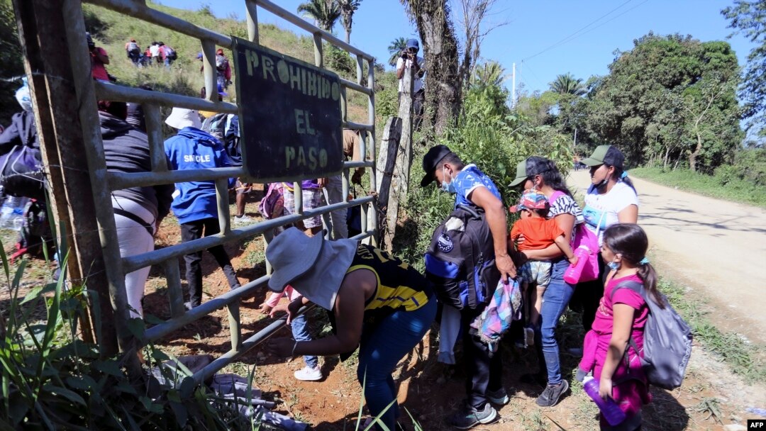 Migrantes que quieren llegar a EE. UU., en su mayoría hondureños y nicaragüenses, cruzan de Honduras a Guatemala a través de un sendero ilegal, en Corinto, Honduras, el 15 de enero de 2022.