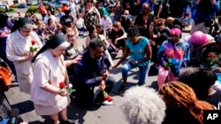 People pray outside the scene of a shooting at a supermarket in Buffalo, New York, May 15, 2022. 