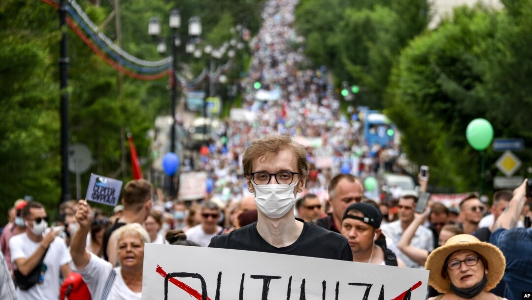 A man holds a poster reading "Putinizm" during an unsanctioned protest in support of Sergei Furgal, the governor of the Khabarovsk region, who was interrogated and ordered held in jail for two months, in Khabarovsk, Russia, July 25, 2020. 