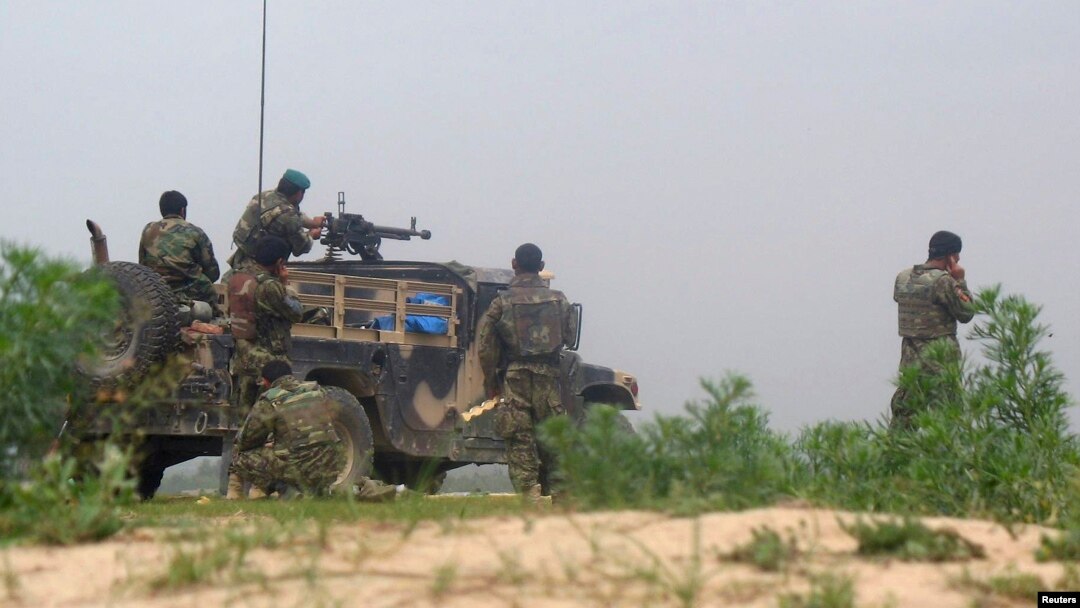 FILE - Afghan soldiers fire a machine gun during a gun battle with Taliban forces in Afghanistan's northern Baghlan province, April 15, 2010.