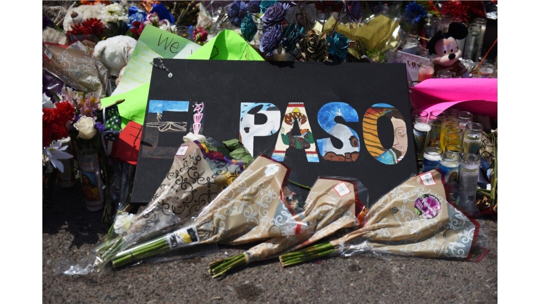FILE - Flowers and candles are left at a memorial five days after a mass shooting at a Walmart store in El Paso, Texas, Aug. 8, 2019.