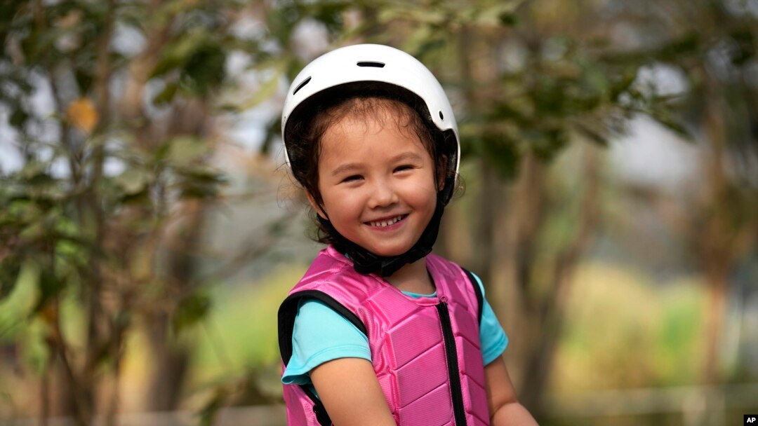 Rylae-Ann Poulin smiles as she learns to ride a horse in Bangkok, Thailand, Saturday, Jan. 14, 2023. (AP Photo/Sakchai Lalit)