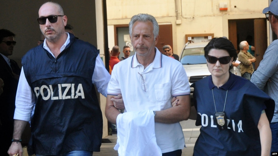 Italian police officers escort Francesco Inzerillo (C) after he was arrested in Palermo during an police/FBI operation called 'New Connection' on July 17, 2019. 