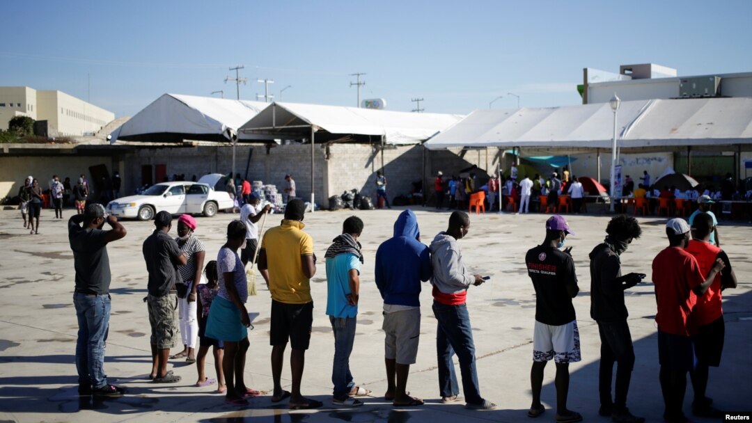 Migrants from Haiti, who returned to the Mexican side of the border to avoid deportation, queue for breakfast at a shelter set by the National Migration Institute (INM) in Ciudad Acuna, Sept. 25, 2021. 