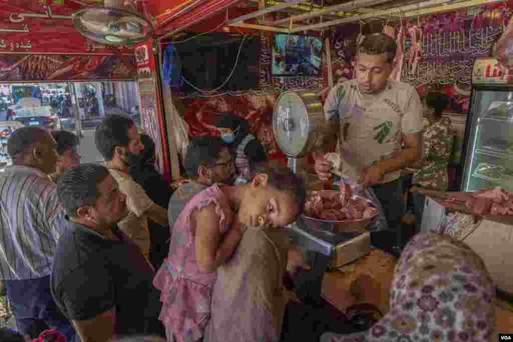 Customers line up at a butcher's shop to buy meat for the holiday, July 19, 2021.