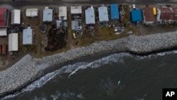 Small waves crash into reinforced seawalls in Shishmaref, Alaska, Tuesday, Oct. 4, 2022. (AP Photo/Jae C. Hong)