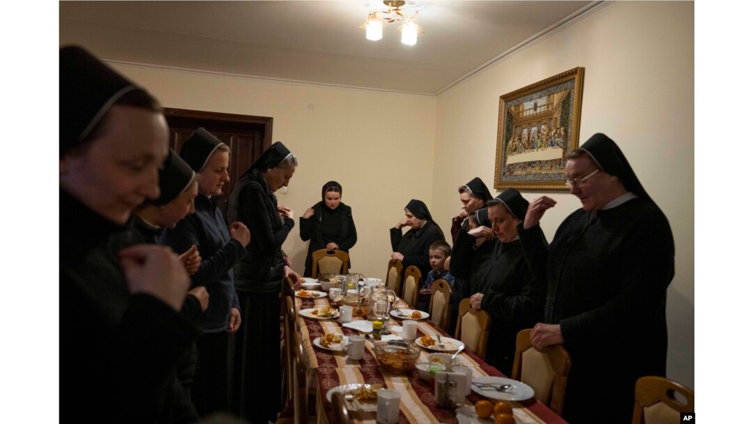 Nuns make prayers after eating dinner, at the Hoshiv Women Monastery, where they have been taking in internally displaced families fleeing the war, in Ivano-Frankivsk region, western Ukraine, April 6, 2022. (AP Photo/Nariman El-Mofty)