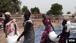 FILE - Displaced people in Bor, South Sudan, collect food aid earlier this year. The conflict in Ukraine and resulting sanctions on Russia are driving up global oil and food prices, which could lead to increased hunger in Africa, analysts say. (Kate Bartlett/VOA)