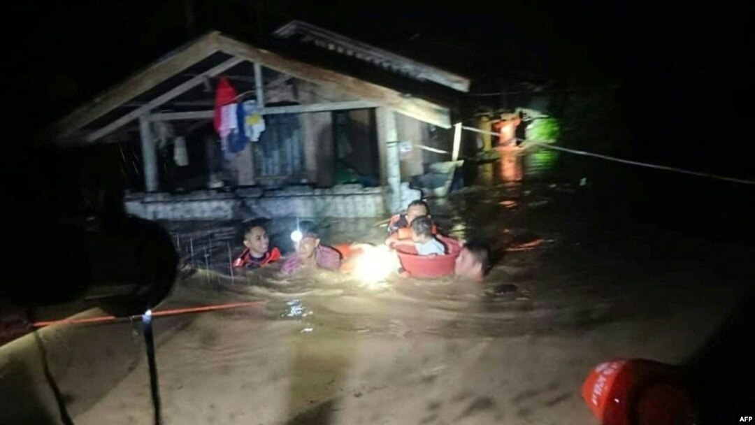 This handout photo taken on Dec. 25, 2022 and received on Dec. 26 from the Philippine Coast Guard shows rescuers evacuating people from a flooded area in Ozamiz City, Misamis Occidental.