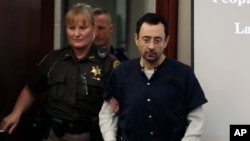 FILE - Dr. Larry Nassar is escorted into court during the seventh day of his sentencing hearing Wednesday, Jan. 24, 2018, in Lansing, Mich. Nassar has admitted sexually assaulting athletes when he was employed by Michigan State University and USA Gymnastics.