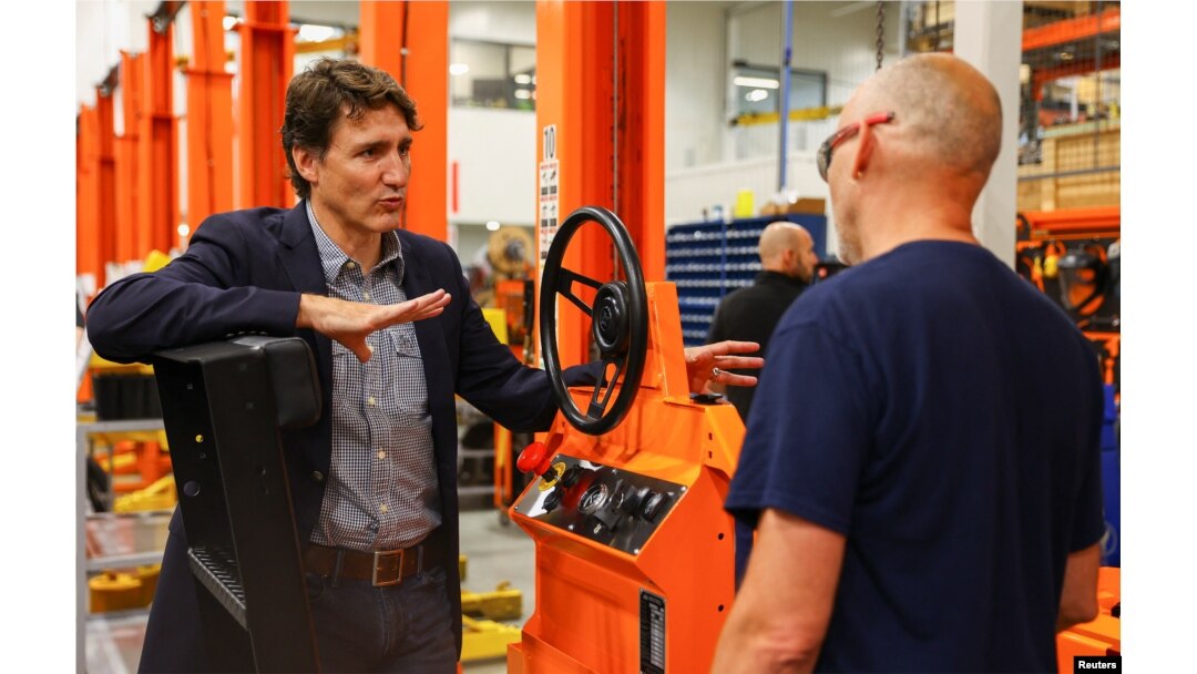 Canada's Prime Minister Justin Trudeau speaks with a worker during his tour at the factory of Motrec International, a company that builds customizable electric industrial vehicles, in Sherbrooke, Quebec, Canada, July 12, 2022.