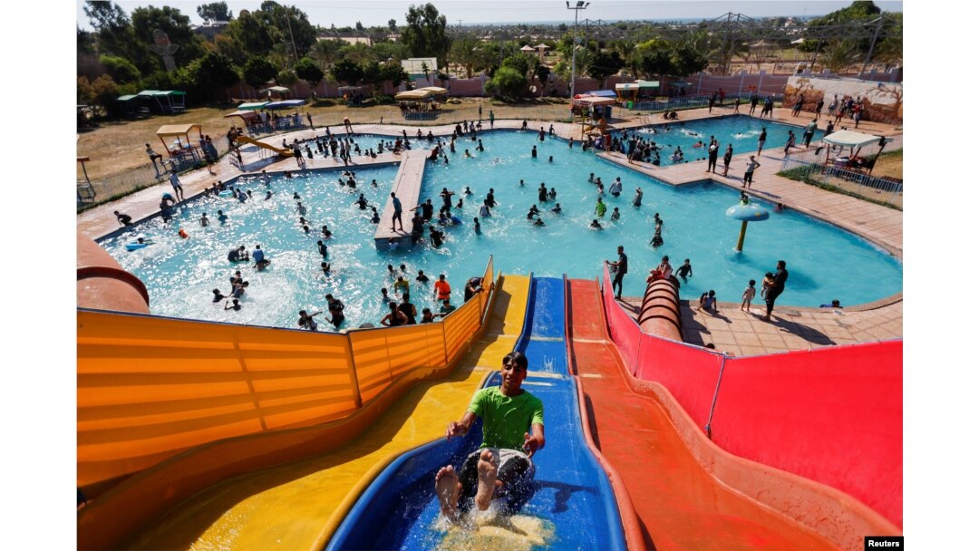 FILE - Palestinians play inside a swimming pool to cool down during a hot weather, in Khan Younis in the southern Gaza Strip, July 20, 2022.
