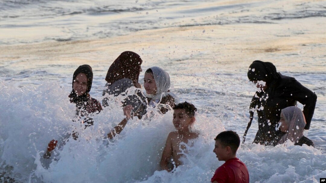 FILE - Palestinians cool off at the beach along the Mediterranean Sea, in Beit Lahia, northern Gaza Strip, July 22, 2022. 