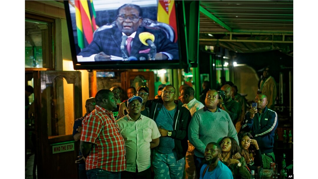 Zimbabweans watch a televised address to the nation by President Robert Mugabe at a bar in downtown Harare, Zimbabwe, Nov. 19, 2017.