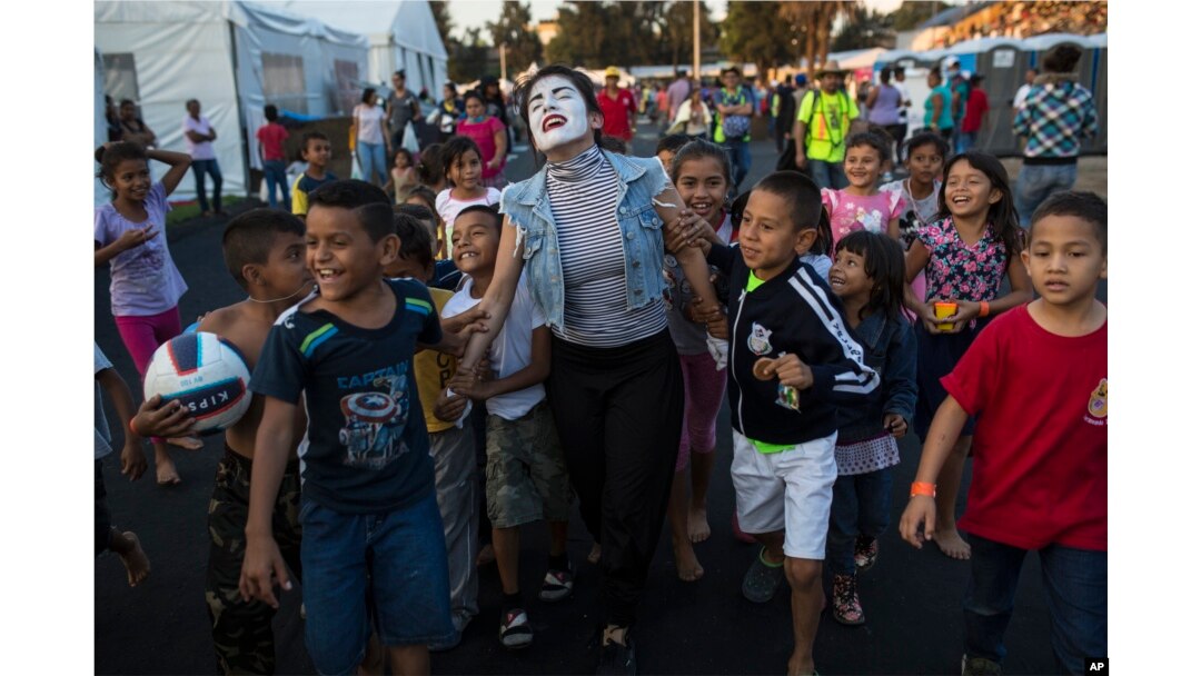 A woman performs as a mime for Central American migrant children at the Jesus Martinez stadium in Mexico City, Tuesday, Nov. 6, 2018.