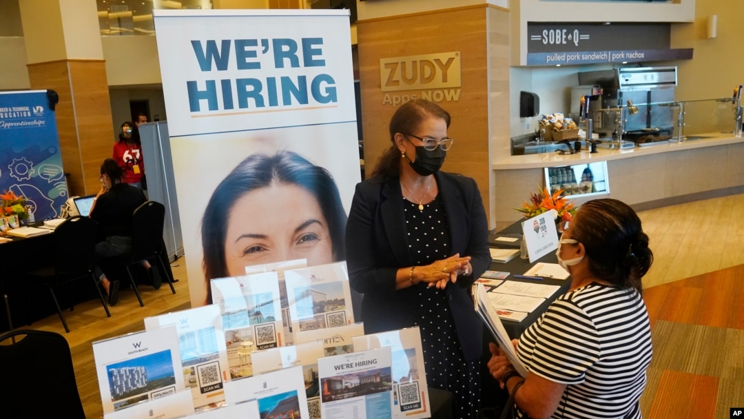 FILE - Marriott human resources recruiter Mariela Cuevas, left, talks to Lisbet Oliveros, during a job fair in Florida, Sept. 3, 2021.