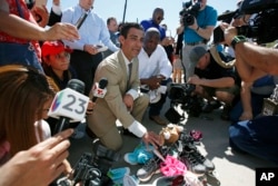 FILE - Miami Mayor Francis Suarez, left, and Columbia, South Carolina Mayor Steve Benjamin explain to the media the symbolic gesture of bringing shoes as gifts for immigrant children that are being held at a facility in Tornillo, Texas, June 21, 2018.