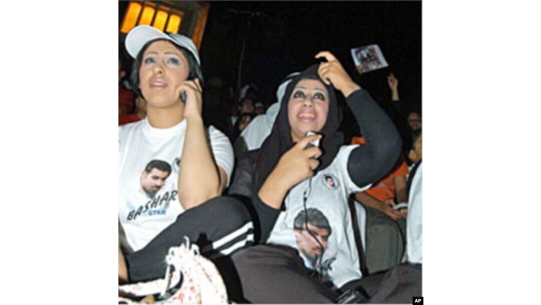In this 2004 file photo, Kuwaiti women sitting in front of a screen use mobiles to vote for their national Bashar Al-Shatti who was competing for title of pan Arab entertainment program "Star Academy"